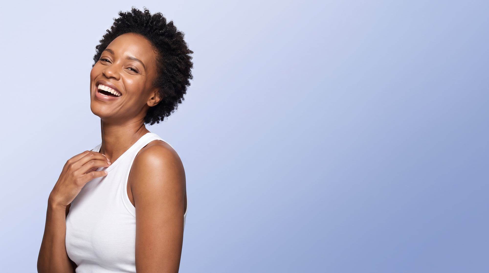 A woman in her thirties laughing, on a periwinkle blue background.