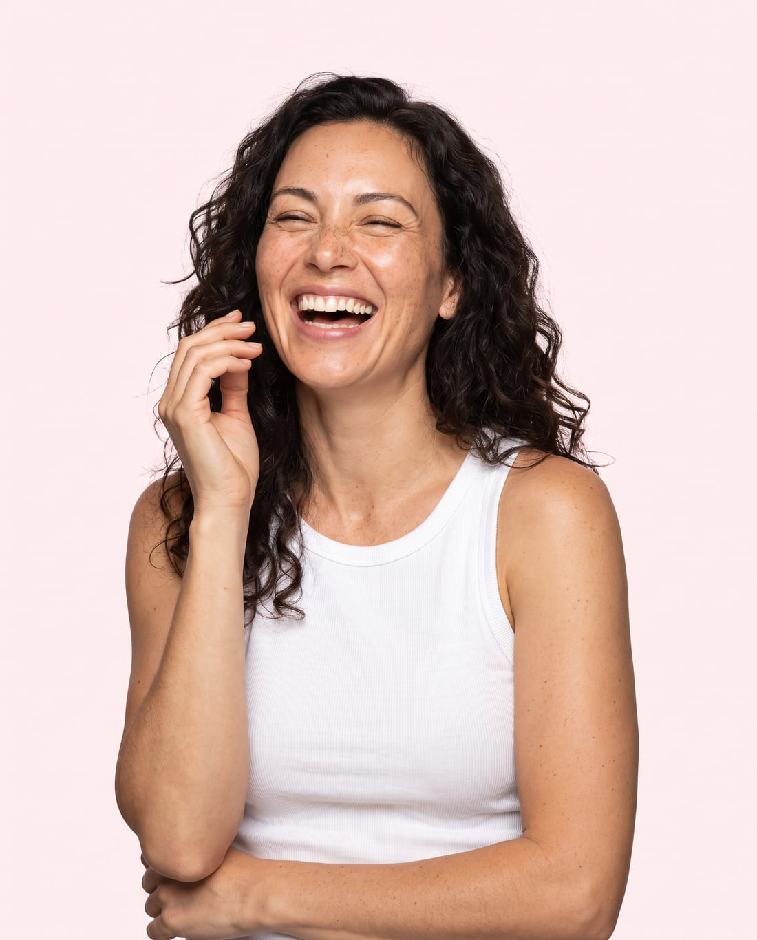 A woman in her forties laughing, the lines at the corners of her eyes fully visible.